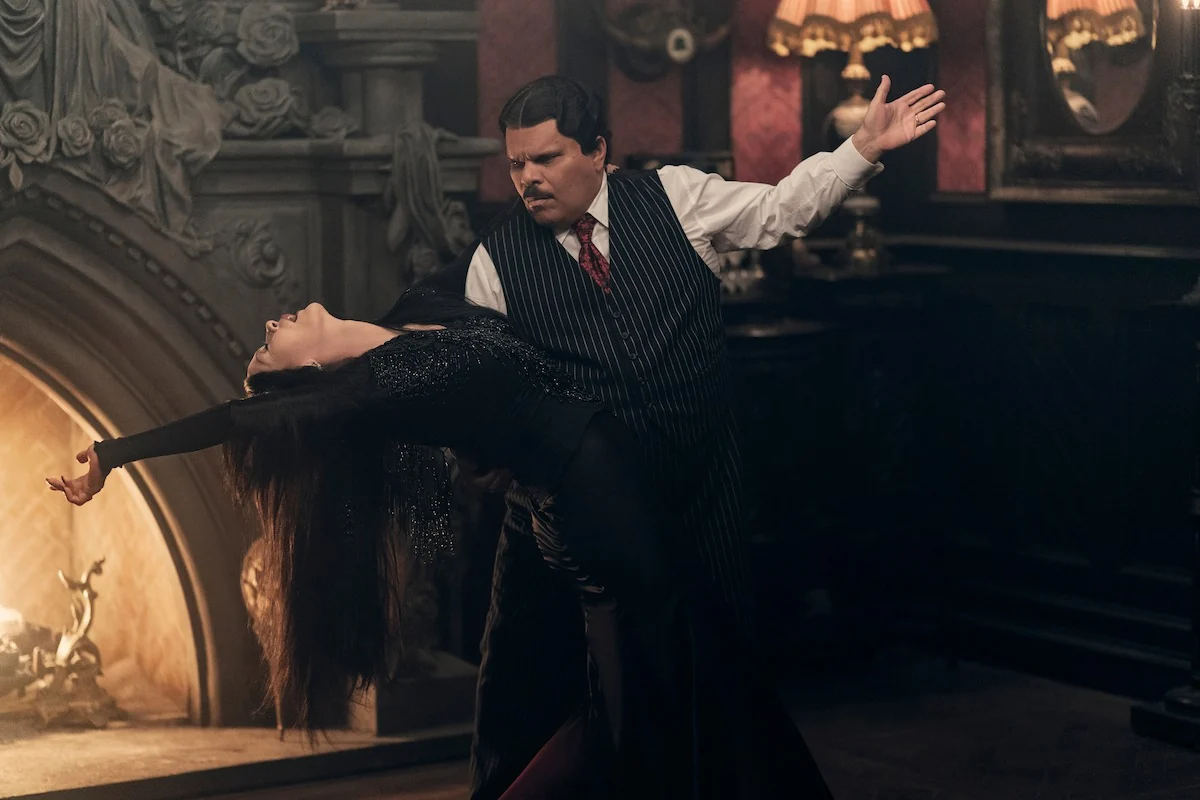 Catherine Zeta-Jones as Morticia Addams and Luis Guzman as Gomez Addams tango together in Wednesday Season 2