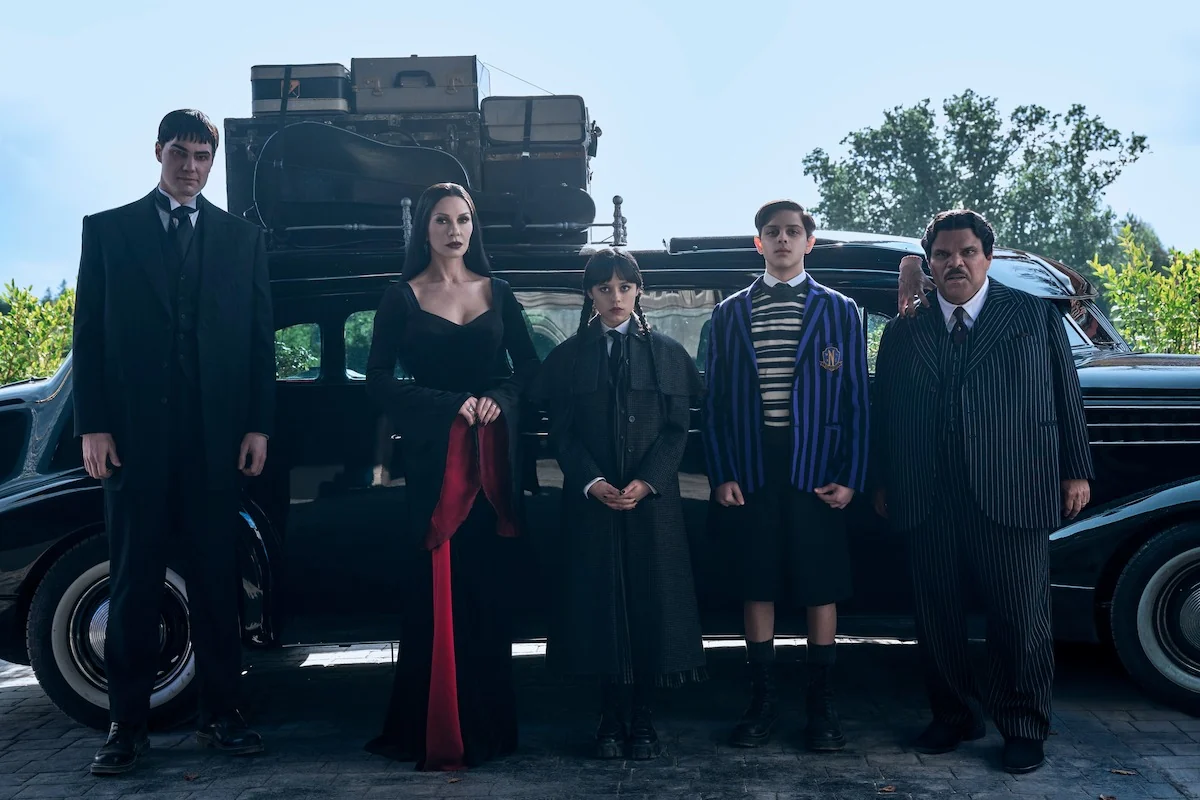 The Addams family, including Jenna Ortega as Wednesday, gathers in front of their car in Wednesday Season 2